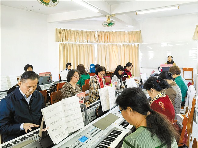 汕头开放大学电子琴班课堂上，学员在老师指导下认真学习。