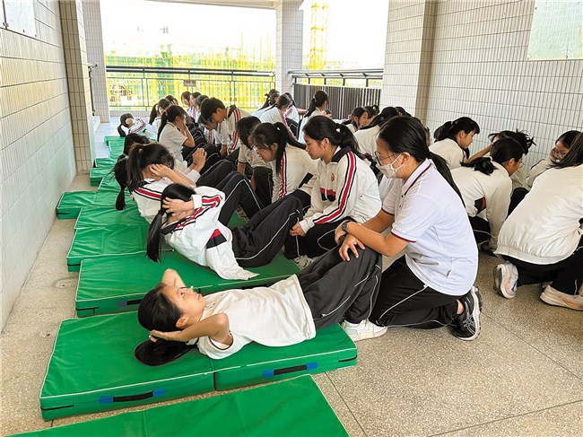 课间时间学生完成仰卧起坐的练习。